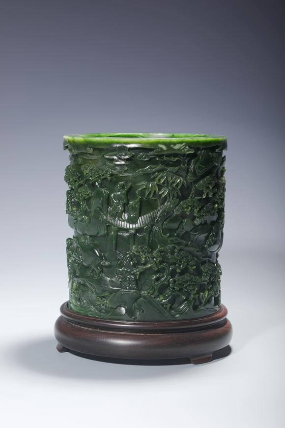 SEAVIEW AUCTIONS PTY LTDA Spinach Green Jade Cylindrical Brush Pot Carved with Mountain and Scholar Landscape, Wood Stand, China, 18th century