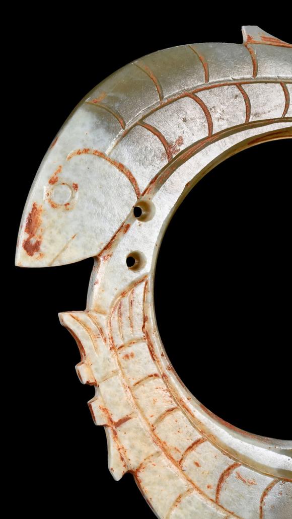 Castle AuctionA Pale Jade Dragon-Ring Pendant with Red Pigment Traces, Han, Circa 2nd C BC–2nd C AD Pr.
