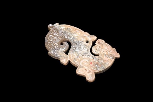 Castle AuctionA Mottled Calcified Jade S-Shaped Dragon Plaque, Spring & Autumn, Circa 8th–5th C BC Pr.