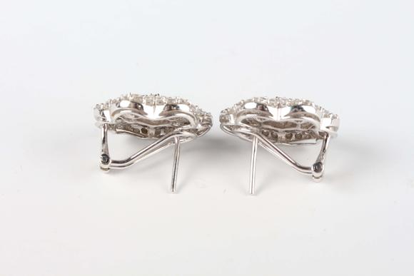 TooveysA pair of white gold and diamond earrings, each in a flowerhead shaped design, mounted with circular and tapered baguette cut diamonds, with post and