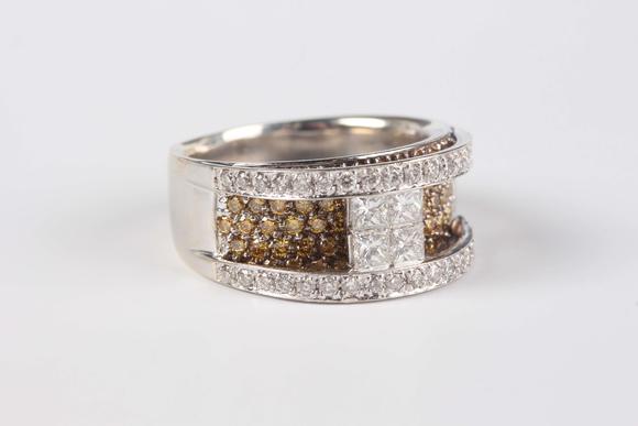 TooveysA white gold, diamond and treated yellow diamond ring in a raised design, the centre set with four principal princess cut diamonds between circular cu