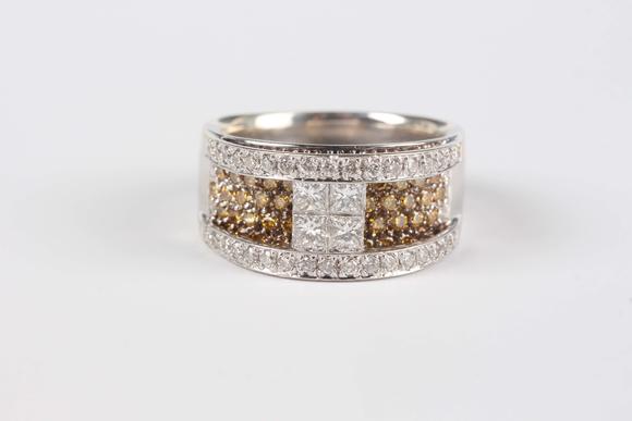 TooveysA white gold, diamond and treated yellow diamond ring in a raised design, the centre set with four principal princess cut diamonds between circular cu