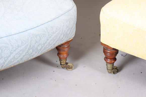 TooveysA near pair of late Victorian Howard & Sons armchairs, each buttoned back above scroll arms, on turned walnut legs with gilt brass caps and castors, e