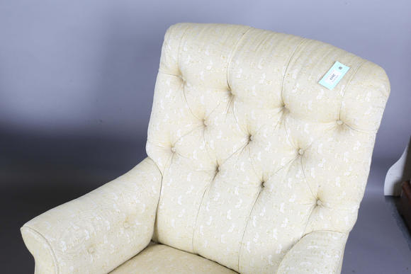 TooveysA near pair of late Victorian Howard & Sons armchairs, each buttoned back above scroll arms, on turned walnut legs with gilt brass caps and castors, e