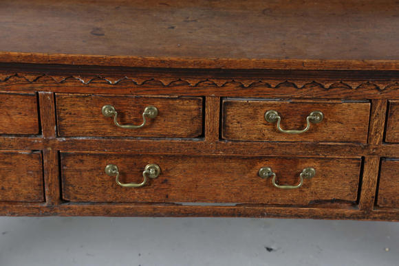 TooveysA good George III North Country oak dresser, the plate rack with pierced side panels above a lappet carved frieze and an arrangement of nine drawers,