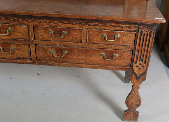 TooveysA good George III North Country oak dresser, the plate rack with pierced side panels above a lappet carved frieze and an arrangement of nine drawers,