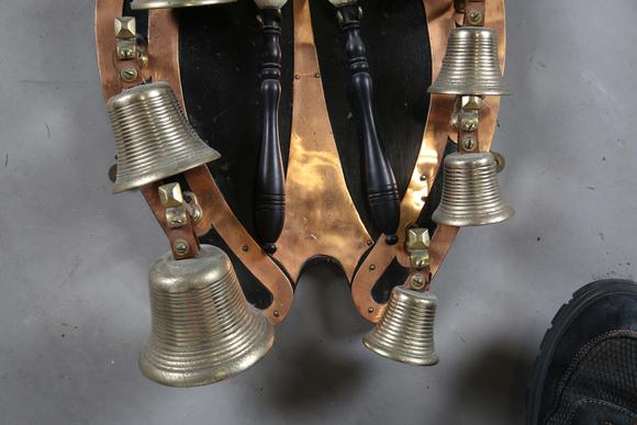 TooveysAn early 20th century copper mounted bell rack, hung with eight musical bells and two hammers, height 50cm.?Provenance: from the estate of a Sussex g