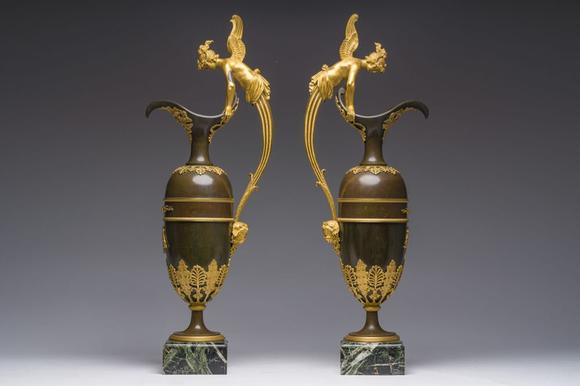 Coronari Auctions BVAn impressive pair of French Empire gilt and patinated bronze ewers on marble bases, attributed to Claude Galle, ca. 1800-1810