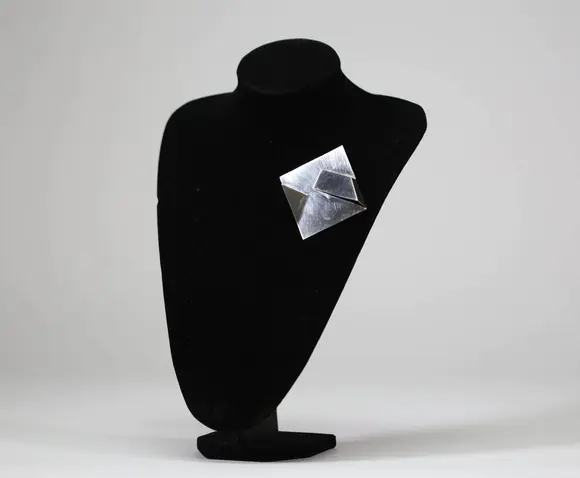 Goldfield Auction sarlsModernist brooch in 925/1000 silver, geometric shape with folded panels in relief, Italian work signed Carlo Lorenzetti, dated 1976.
Limited edition of 28, numbered and signed on the reverse, published by Galleria La Polena, Genoa.
A sculptural aesthetic characteristic of Italian research in the 1970s, in good overall condition.
Condition : Good
Height : 2 cm 
Width : 6 cm
Weight : 32,6 gr