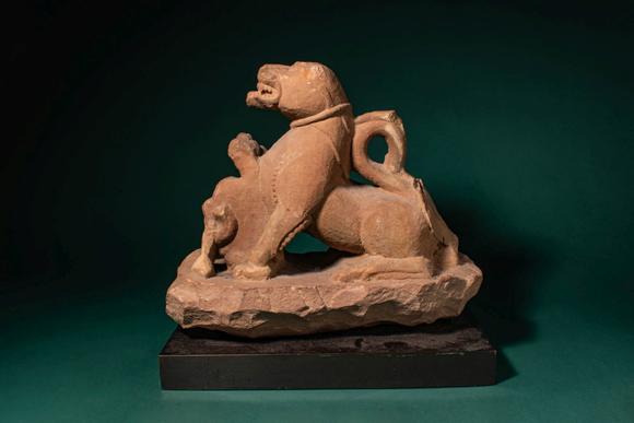 Apollo Art AuctionsCa. 11th - 12th century AD. >
A carved sandstone sculpture depicting a recumbent lion, shown with
