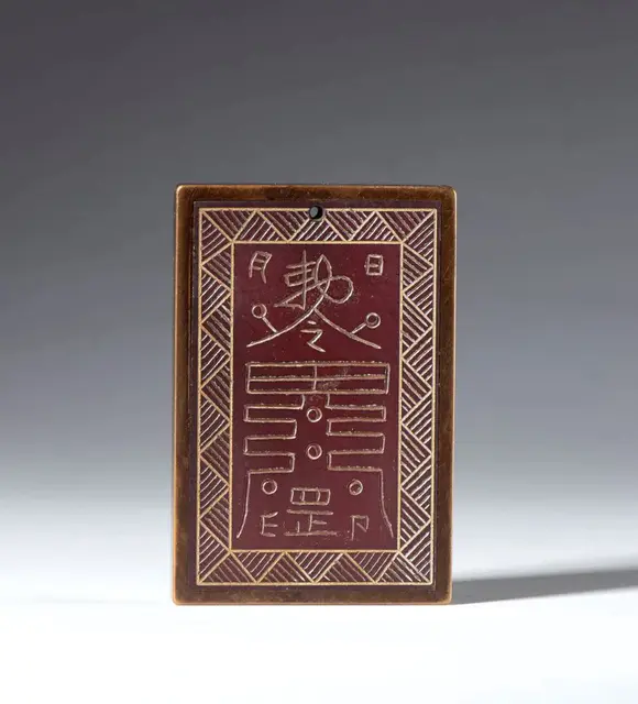Bertolami Fine ArtA Taoist plaque in Hetian red jade, with a hanging hole. China, Qing Dynasty (1644–1911), 19th century.
