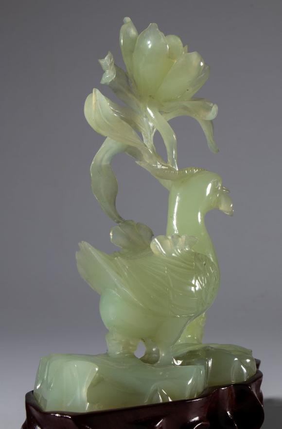 Bertolami Fine ArtGreen jade sculpture on a wooden base depicting a pair of birds and a large flower. China, 20th century.