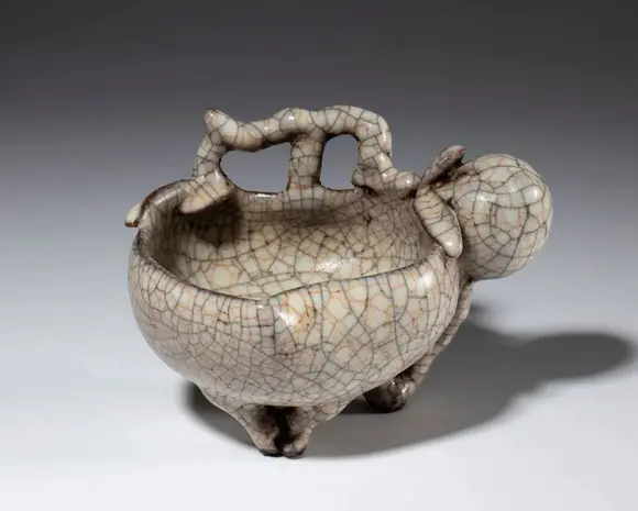 Bertolami Fine ArtA crackled-glaze ceramic bowl in the shape of a fruit. China, 20th century.