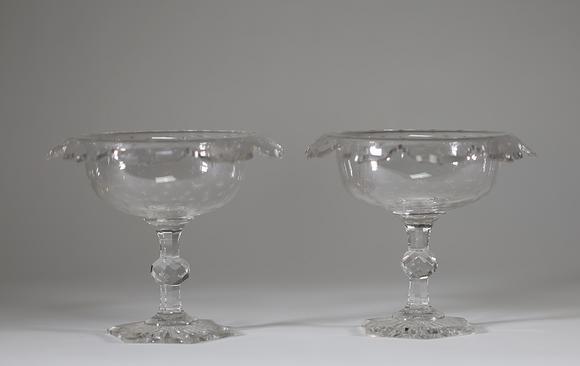 Goldfield Auction sarlsPaire de drageoirs en cristal taillé et gravé, reposant sur un piédouche à pans coupés, la coupe à bord contourné ornée d’un décor d’étoiles gravées