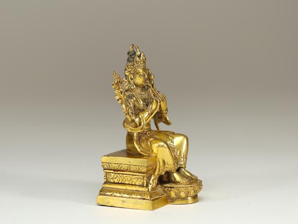 Goldfield Auction sarlsTravail sino-tibétain, XVIIe siècle sculpture en bronze doré représentant une divinité bouddhique assise en vajrāsana sur un socle lotiforme, les main