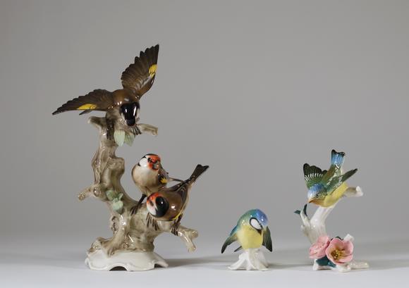 Goldfield Auction sarlsLot de trois sujets animaliers en porcelaine polychrome figurant des oiseaux branchés, comprenant un groupe de chardonnerets et deux petits oiseaux su