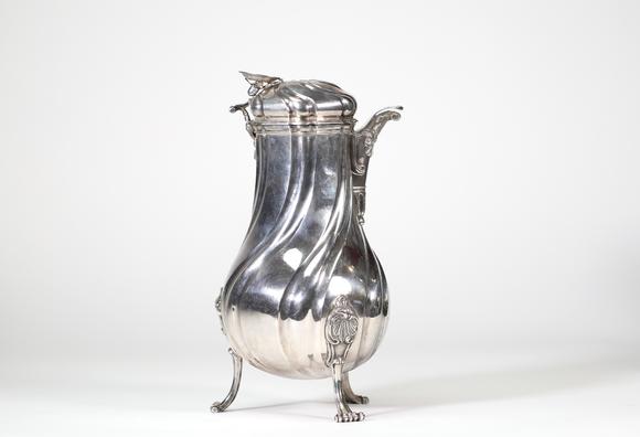 Goldfield Auction sarlsGrande chocolatière en argent massif reposant sur trois pieds cambrés, à décor de c?tes torses et appliques rocaille, bec verseur feuillagé, couvercle
