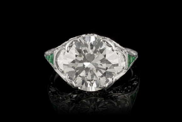 Piguet - H?tel des VentesBague Art Déco platine centrant un diamant taille brillant entouré de diamants taille demi-lune et 8/8 ainsi que d'émeraudes calibréesArt Déco platinum ring set with one center diamond, half-moon and 8/8 cut diamonds and calibrated-cut emeralds