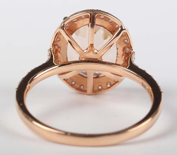 TooveysAn 18ct gold, morganite and diamond oval cluster ring, claw set with