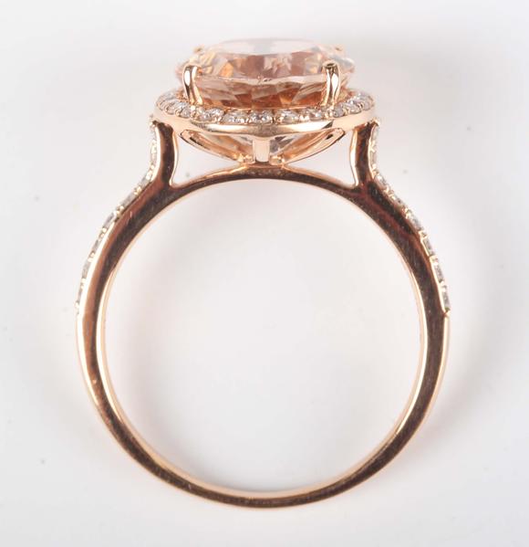 TooveysAn 18ct gold, morganite and diamond oval cluster ring, claw set with