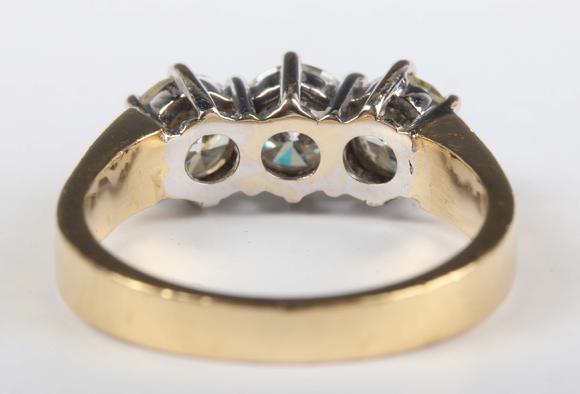 TooveysAn 18ct gold and diamond three stone ring, claw set with a row of ci