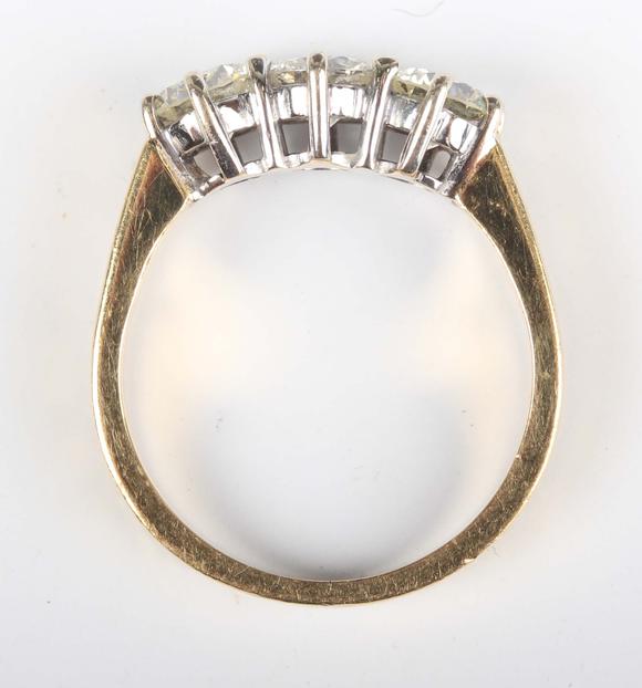 TooveysAn 18ct gold and diamond three stone ring, claw set with a row of ci