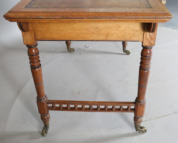 TooveysA late Victorian oak writing table, the top inset with gilt-tooled b