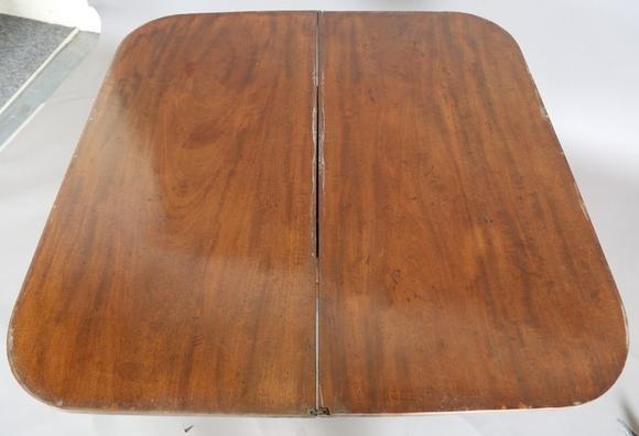 TooveysA Regency mahogany fold-over tea table, raised on a spiral reeded st