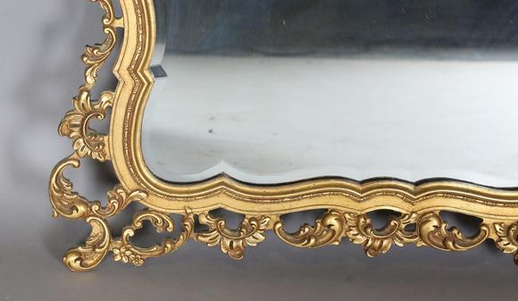 TooveysA late 20th century gilt composite wall mirror of shaped form, the f