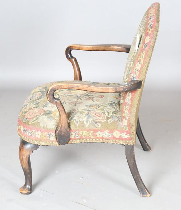 TooveysAn early 20th century walnut framed low armchair with a woolwork sea