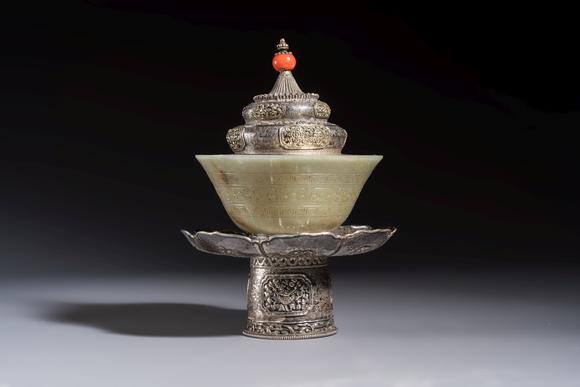 Rob Michiels AuctionsA Tibetan ritual jade bowl with a red coral-mounted silver cover and a stand, 19th C.