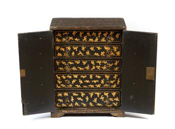 A Japanese black lacquered miniature cabinet