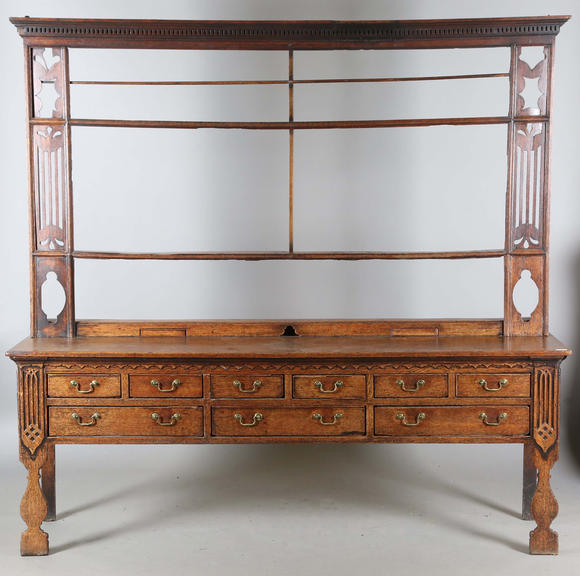 Tooveys|中西方古董藝術(shù)A good George III North Country oak dresser, the plate rack with pierced side panels above a lappet carved frieze and an arrangement of nine drawers,