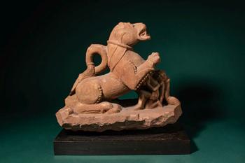 Ca. 11th - 12th century AD. >
A carved sandstone sculpture depicting a recumbent lion, shown with