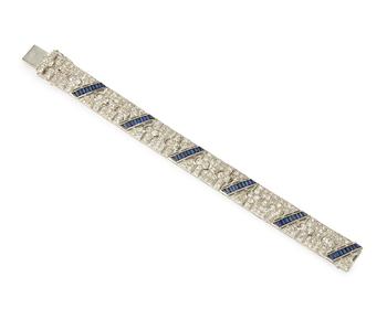 A diamond and sapphire broad flexible bracelet, by Diafini, composed of old-brilliant-cut diamond articulated panels forming parallelogram sections ea