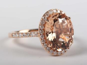 An 18ct gold, morganite and diamond oval cluster ring, claw set with