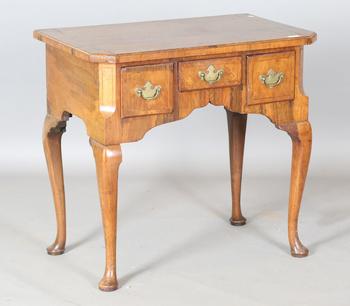 An 18th century and later walnut lowboy, fitted with three oak-lined