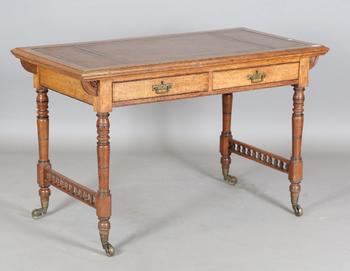 A late Victorian oak writing table, the top inset with gilt-tooled b